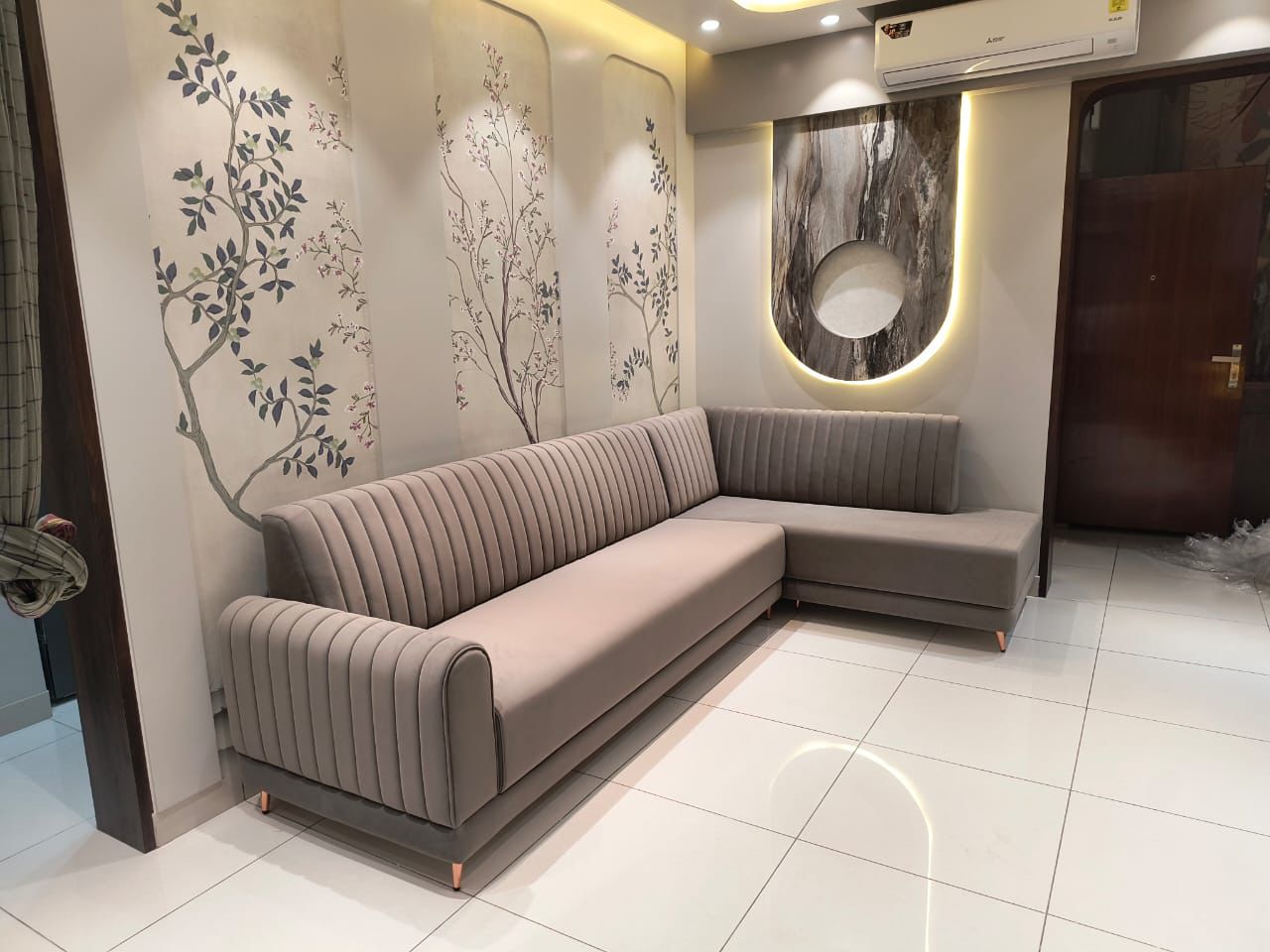 Taupe channel-tufted L-shaped sofa against a chinoiserie wall